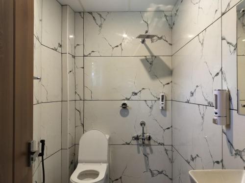 a bathroom with a toilet and a sink at IvyArk Residency in Pinangode