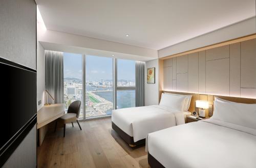 Postel nebo postele na pokoji v ubytování Wyndham Grand Busan
