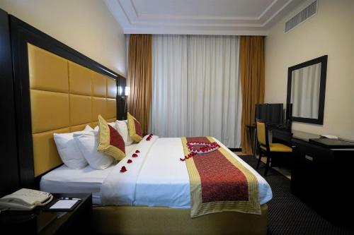 a hotel room with a large bed and a desk at Royal Beach Hotel & Resort in Dibba