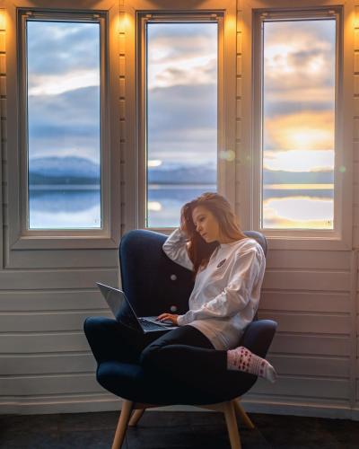 two women sitting in a chair with a laptop at Norwegian Wild in Vangsvik