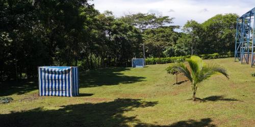 un parque con dos cubos de basura azul y una palmera en Finca Vicky y el El abuelo, en Labrador