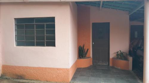 dom z drzwiami i oknem i roślinami w obiekcie Sítio Gacied w mieście Suzano