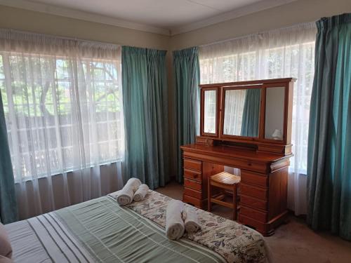 a bedroom with a dresser and a mirror and a bed at Charming Randburg Accommodation near the Olivedale Clinic in Sandton