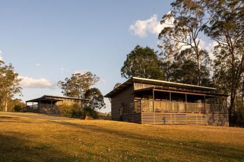 two wooden buildings sitting on top of a grass field at Barrington Riverside Cottages in Barrington