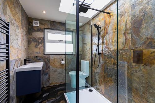 a bathroom with a glass shower and a toilet at 23 Trafalgar Square with hot tub and cinema in Scarborough