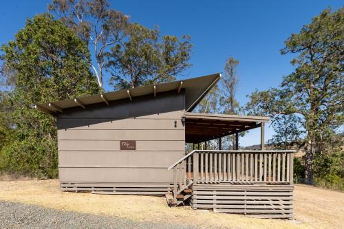a storage shed with a black roof at Barrington Riverside Cottages in Barrington