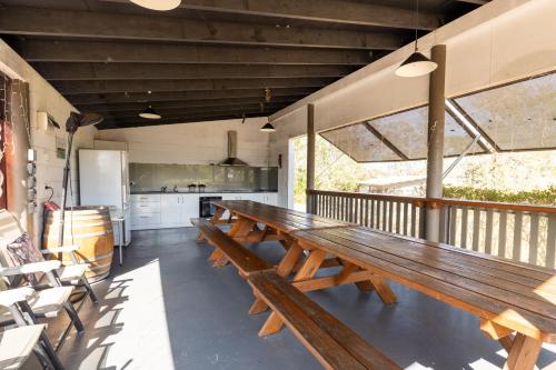 a large wooden bench sitting on a balcony at Barrington Riverside Cottages in Barrington