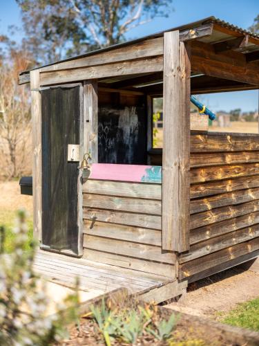 a wooden outhouse with an open door at Barrington Riverside Cottages in Barrington