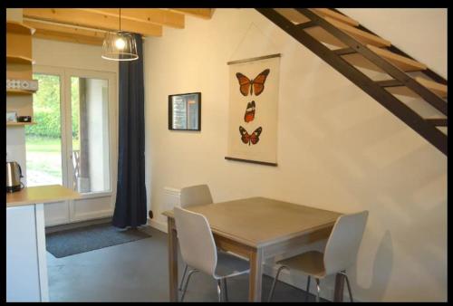 comedor con mesa de madera y sillas en L'Atelier de la Blanchardière 49520, en Le Tremblay