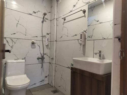 La salle de bains est pourvue de toilettes et d'un lavabo. dans l'établissement IvyArk Residency, à Pinangode