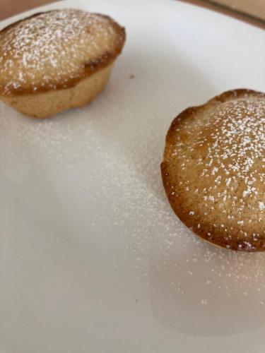 Dois donuts em cima de um prato branco. em Piccolo Hotel Villa Rosa em Ostuni