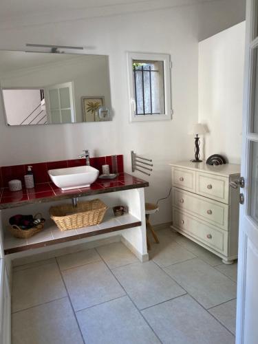 ein Bad mit einem Waschbecken und einem Spiegel in der Unterkunft Mas des Bômes **** in Mérindol