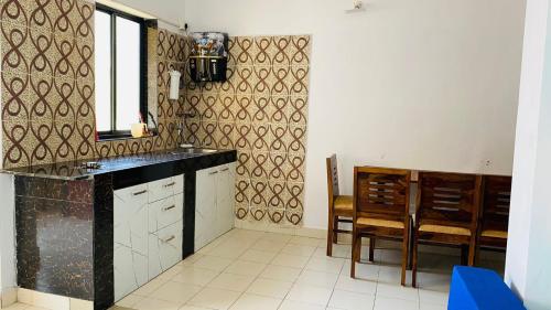 a kitchen with a black counter and a dining room at Holidays Beach Apartments Goa in Baga