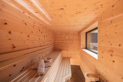 uma sauna de madeira com dois pares de sapatos em Vista Chalets Sexten em Sesto