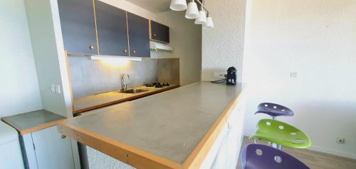 une cuisine avec un comptoir et deux tabourets dans l'établissement Beautiful Vacation Rental in Le Barcars, France, au Barcarès