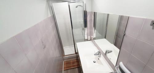 une salle de bain blanche avec un lavabo et une douche dans l'établissement Beautiful Vacation Rental in Le Barcars, France, au Barcarès