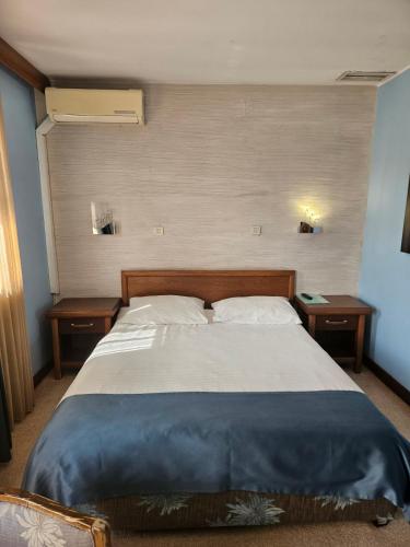 1 dormitorio con 1 cama grande y 2 mesitas de noche en APT Properties en Čukarica