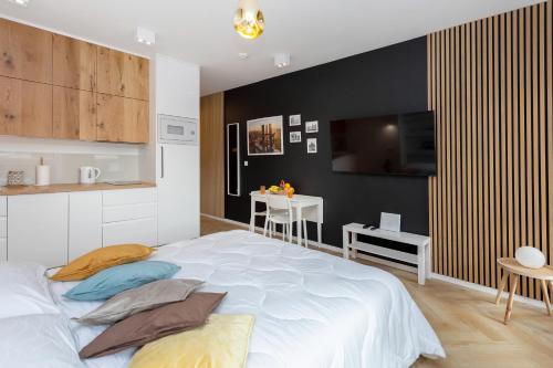 a bedroom with a large white bed and a tv at AVRA Residence II Stare Miasto in Gdańsk