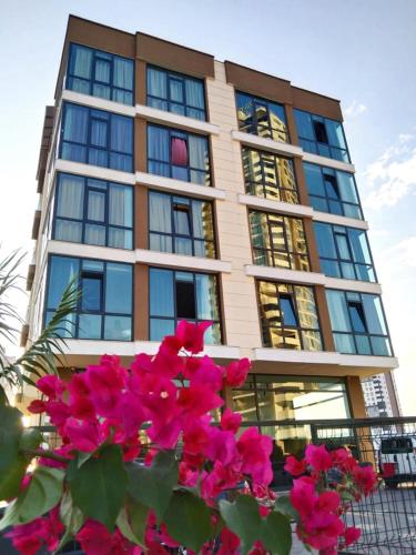 a building with pink flowers in front of it at ATLAS SUİT in Çiftlikköy