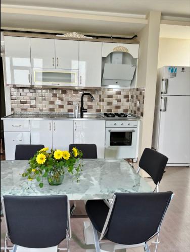 a kitchen with a table with yellow flowers on it at ATLAS SUİT in Çiftlikköy