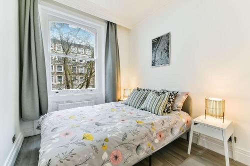 a bedroom with a bed and a window at Knightsbridge Stylish Two Bedroom Apartment in London