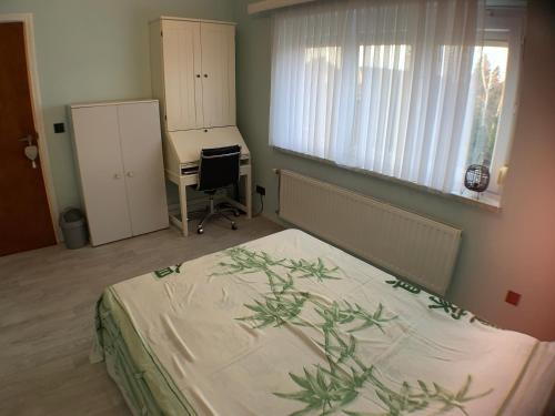 a bedroom with a bed and a desk and a window at Chambre dans habitat partagé chez Séverine in Nivelles