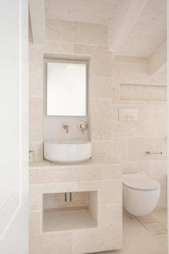 a white bathroom with a sink and a toilet at Tra Cielo e Mare in Vieste