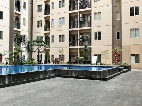 a swimming pool in front of a building at Cozy 2 BR Sudirman Suites Apartment in Bandung