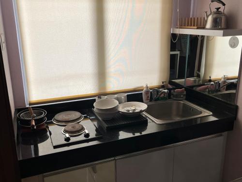 a kitchen counter with a stove and a sink at Cozy 2 BR Sudirman Suites Apartment in Bandung