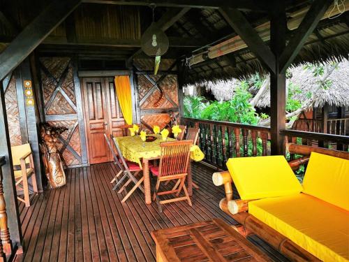 a wooden deck with a table and chairs on it at Fleurdesiles in Nosy Be
