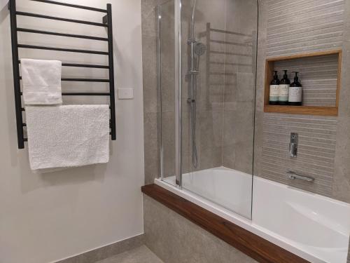 a bathroom with a shower and a bath tub at BestView St Kilda Spectacular Sunset Hideaway - boutique self-contained luxury apartment in Melbourne