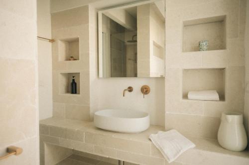 a white bathroom with a sink and a mirror at Tra Cielo e Mare in Vieste