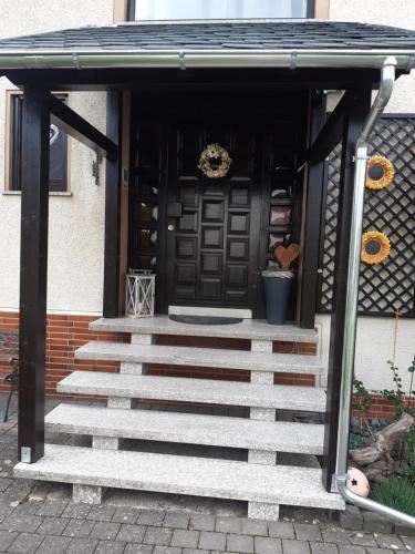 a front door of a house with a set of stairs at Ferienwohnung Sonnenblume 