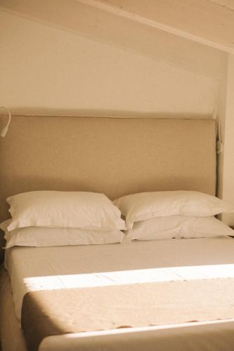 a bed with white sheets and pillows on it at Tra Cielo e Mare in Vieste