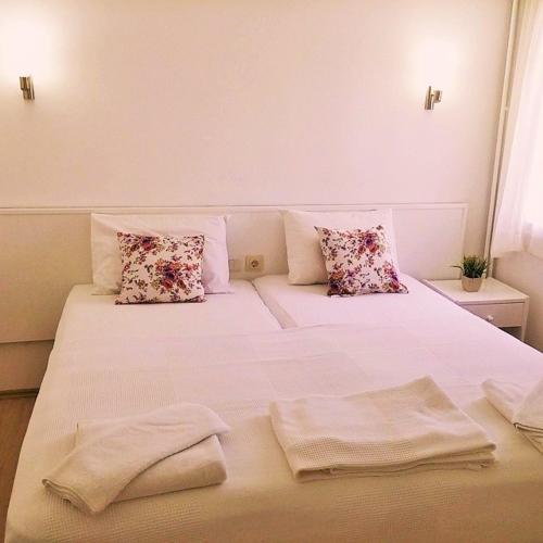 a white bed with pillows and towels on it at Parla Apart Hotel in Çeşme