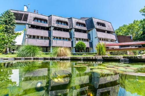 a building with a pond in front of it at Hotel Jogar in Balatonföldvár