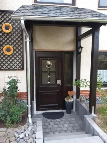 una puerta marrón de una casa con porche en Ferienwohnung Kirschblüte 