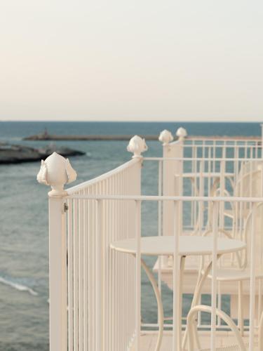 two white chairs on a balcony overlooking the ocean at Tra Cielo e Mare in Vieste