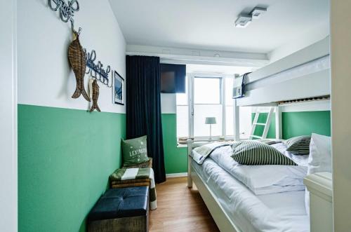 ビンツにあるFeWo Prora - Sealion Penthouseの緑の壁、ベッド付きのベッドルーム1室