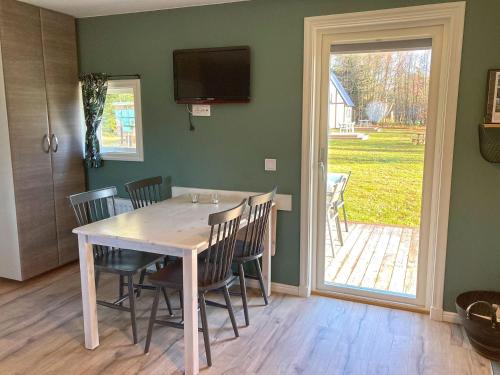a dining room with a table and chairs and a sliding glass door at Sudersand Resort in Fårö