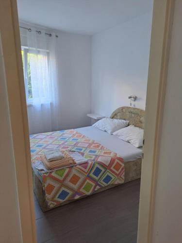 a bedroom with a bed with a quilt on it at Apartment Kricin in Baška