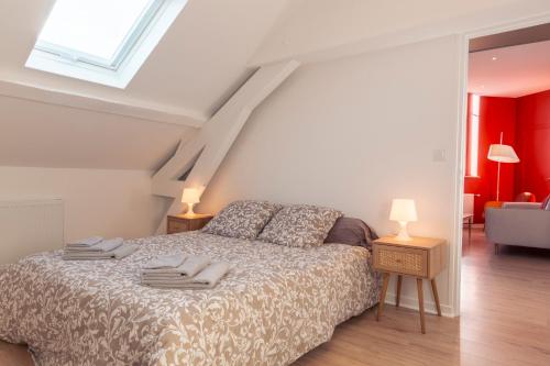 a bedroom with a bed with two towels on it at Suite Germain - 4 pers. in Charleville-Mézières