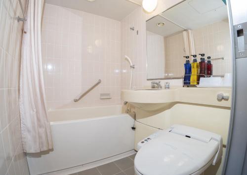 Saka no Hotel Tretio Ochanomizu في طوكيو: حمام مع مرحاض وحوض استحمام ومغسلة
