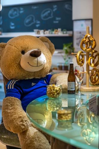 a teddy bear sitting in a chair with a glass table at ibis Styles Strasbourg Stade de la Meinau in Strasbourg