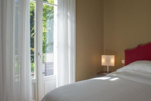 a bedroom with a bed and a large window at Casa Bianca Apartments in Como