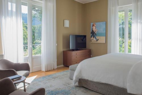 Schlafzimmer mit einem Bett, einem TV und Fenstern in der Unterkunft Casa Bianca Apartments in Como