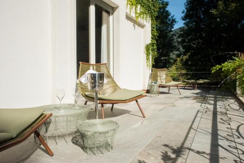 a patio with chairs and tables on a building at Casa Bianca Apartments in Como