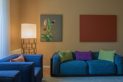 a living room with a blue couch and two chairs at Casa Bianca Apartments in Como