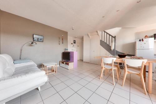 - un salon avec un lit et une table avec des chaises dans l'établissement Appartement pour 6 - 400 plage du Fogeo, à Arzon