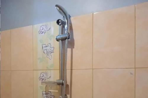 een douche in een badkamer met een douchekop bij OYO 93071 Home Stay Kembar Syariah in Binjai
